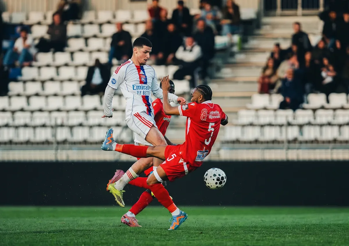 Duel aérien entre deux joueurs devant les tribunes