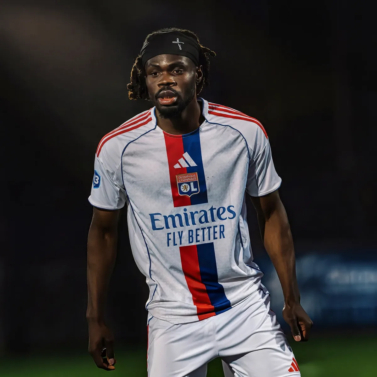 Regard d'un attaquant de l'Olympique Lyonnais sous les projecteurs