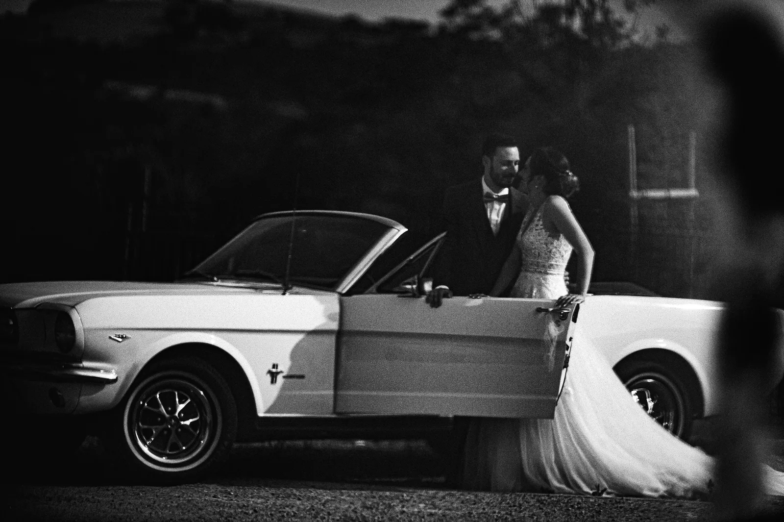 Mariés devant une voiture de collection décapotable, portrait de mariage en noir et blanc