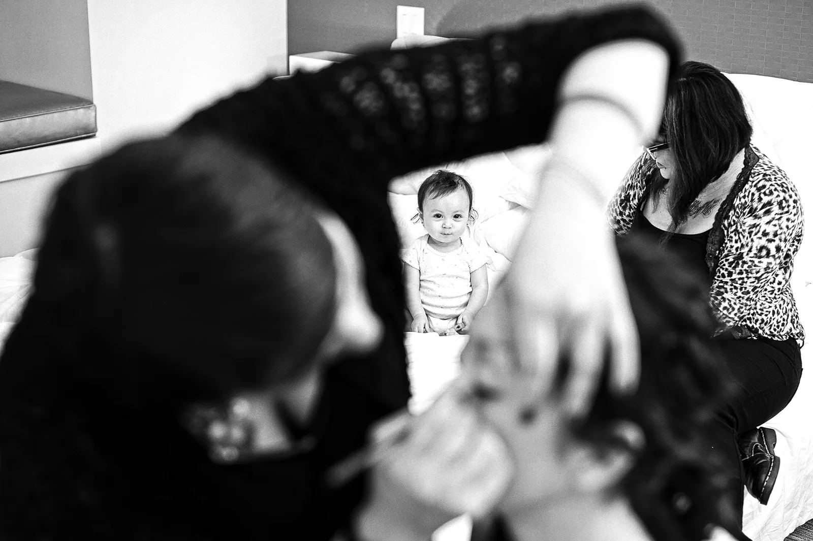 Préparatifs : coiffure et maquillage de la mariée, bébé dans les bras, noir et blanc