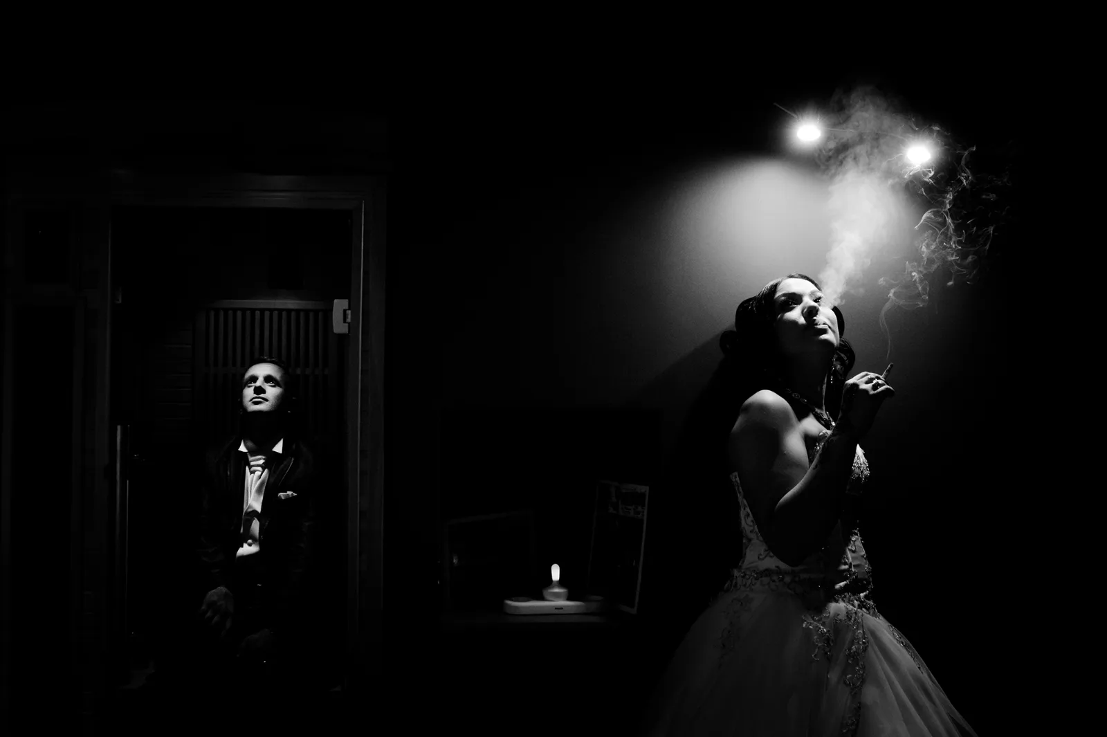 Mariée dans la pénombre éclairée par une lumière douce, portrait artistique en noir et blanc