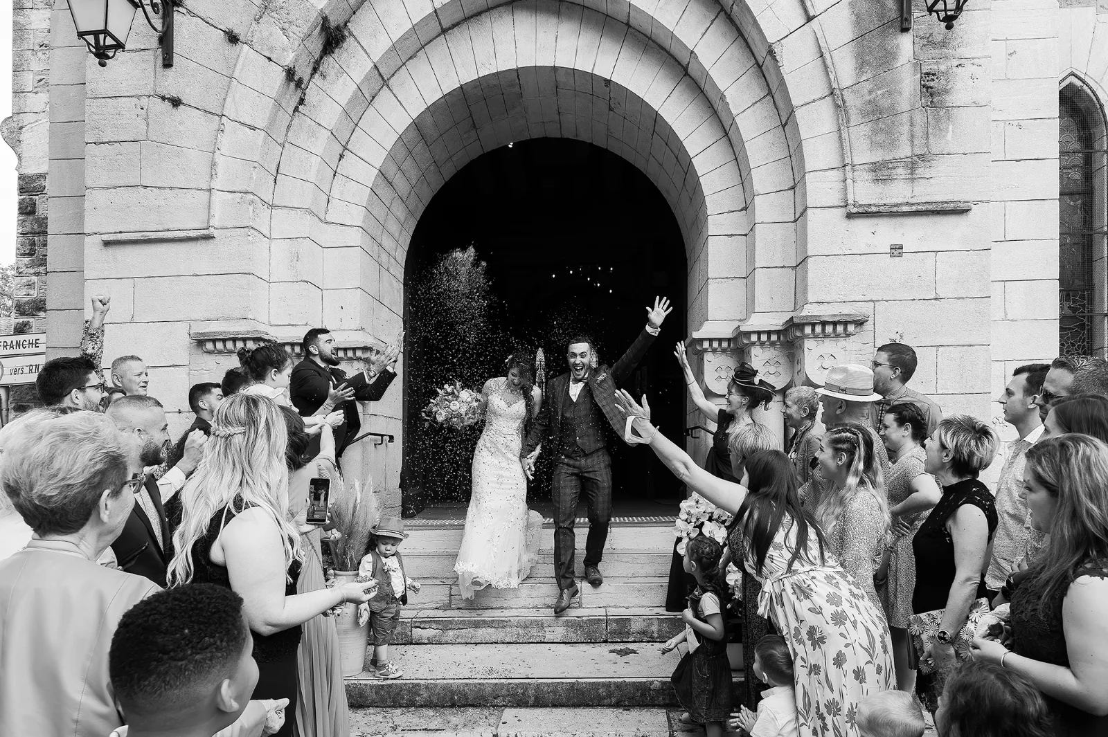 Sortie d'église sous les cris de joie des invités, noir et blanc