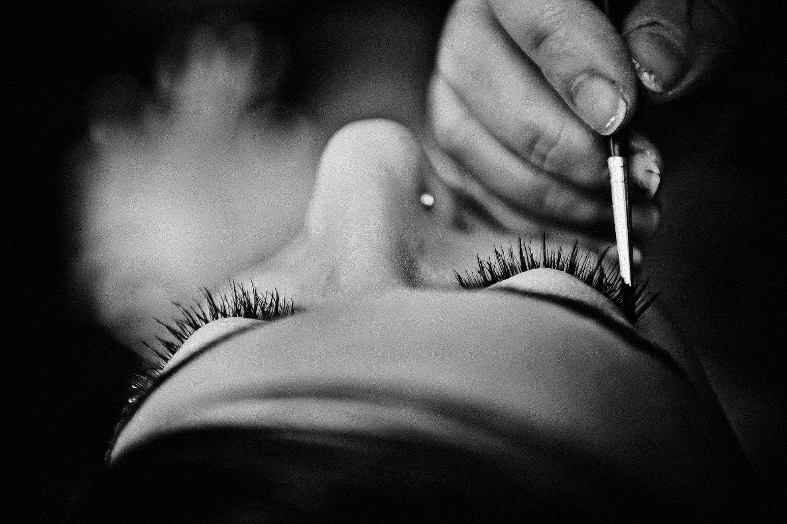 Gros plan sur le maquillage des yeux de la mariée pendant les préparatifs, noir et blanc